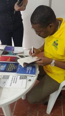 Le directeur de la DNL signe son livre au Salon du livre de Cuba (c) Facebook/DNLhaiti